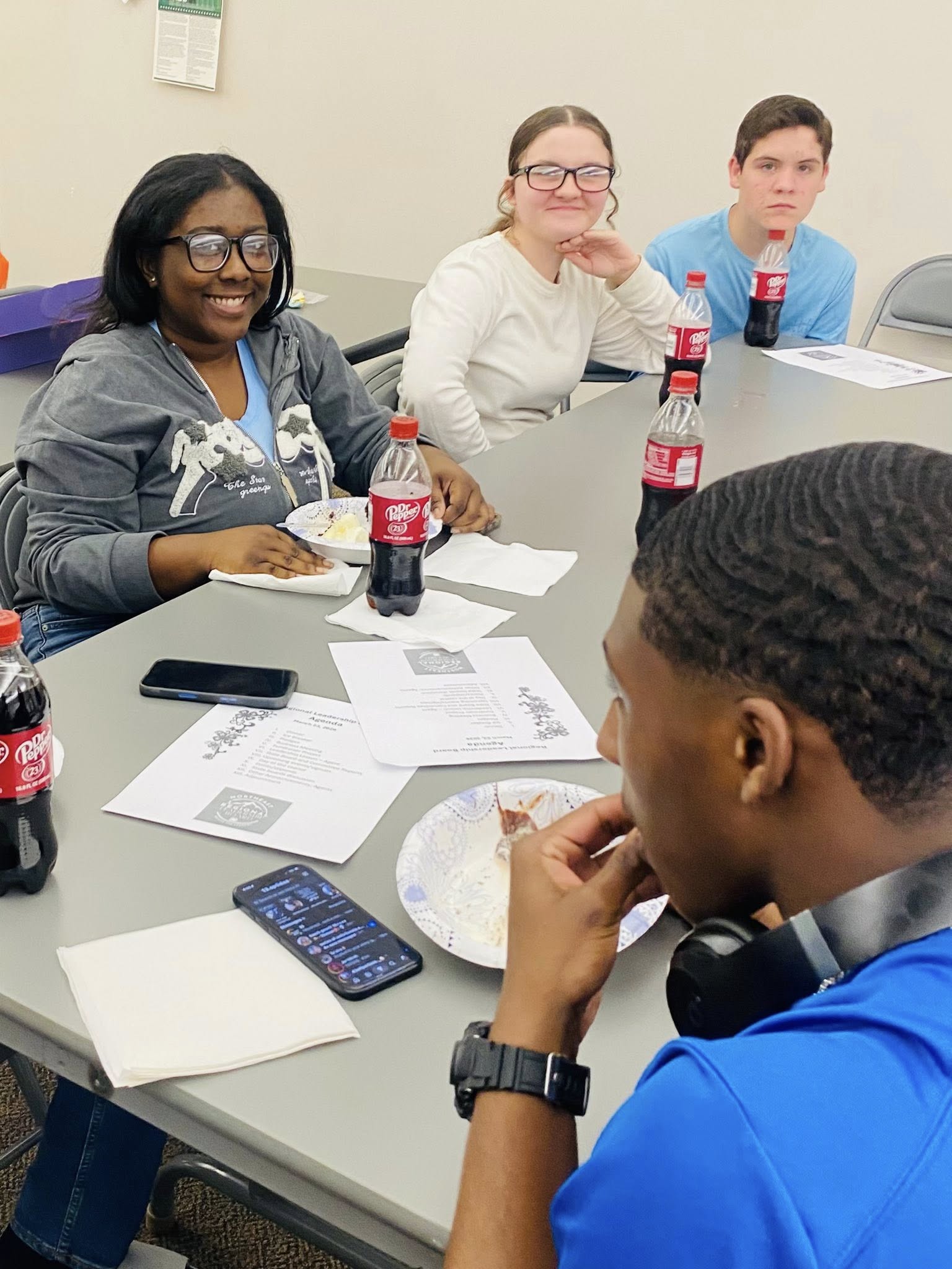 Some teens sitting at a table.